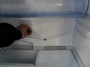 Clogged drain hole in the refrigerator compartment