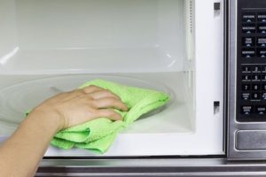 Cleaning the microwave with a dry cloth after use