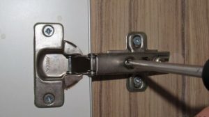 Adjusting the height of the cabinet door.