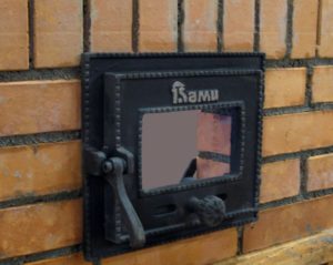 Installing the combustion door of a brick oven