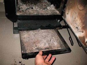 cleaning the ash pan of a solid fuel boiler