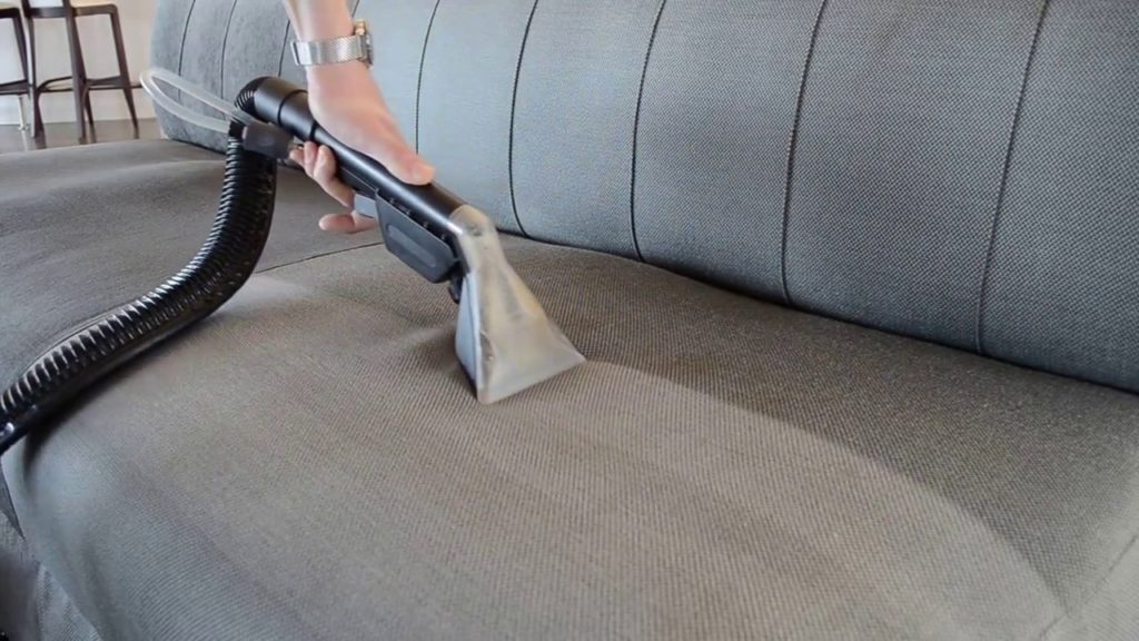 Cleaning upholstered furniture using a steamer.