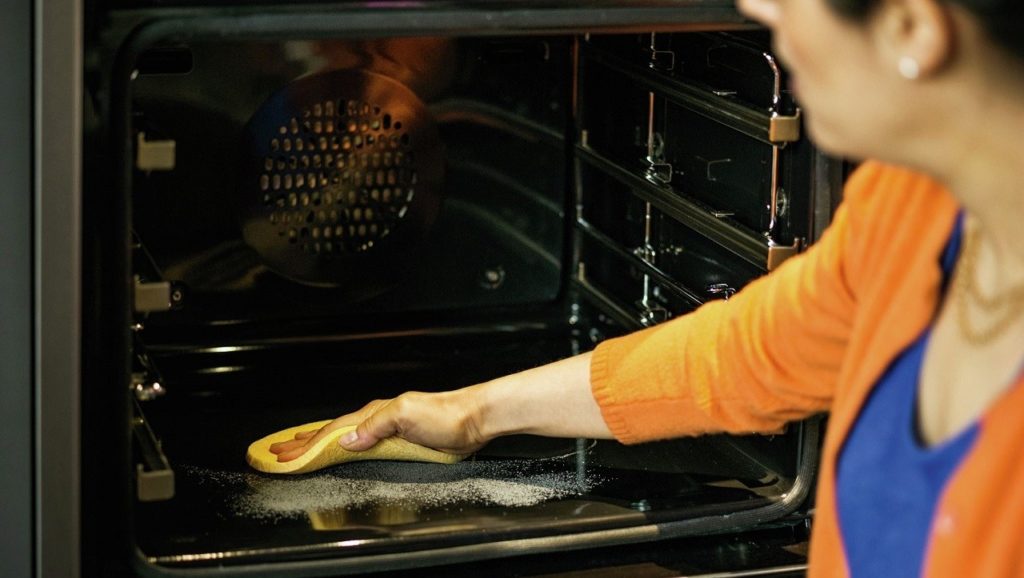Washing the oven.