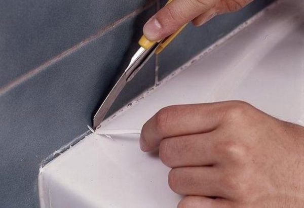 Removing the sealant from the bathtub.