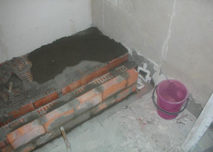 Installing a bathtub on a brick podium.