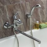 Single lever bath and shower mixer with long spout and shower head.