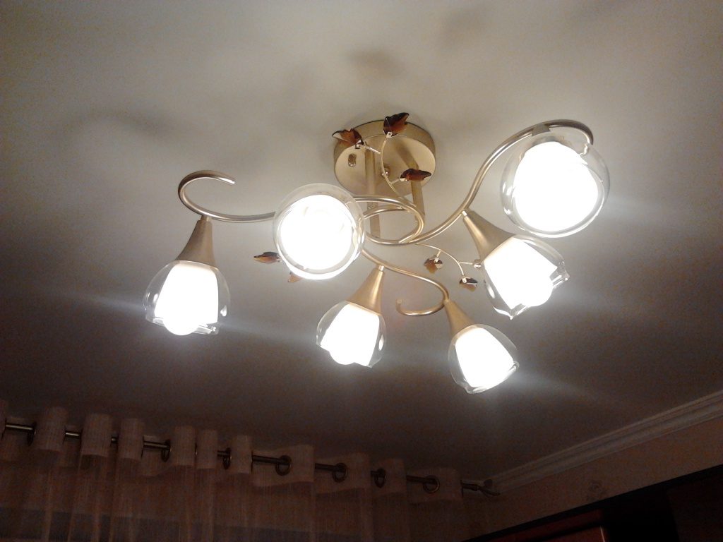 The lamps in the chandelier are blinking.
