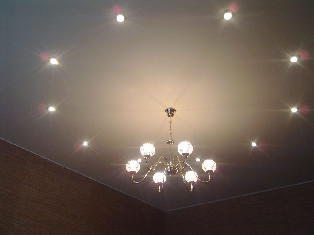 Spotlights and chandeliers on a suspended ceiling.