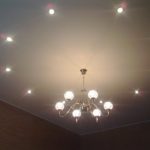 Spotlights and chandeliers on a suspended ceiling.