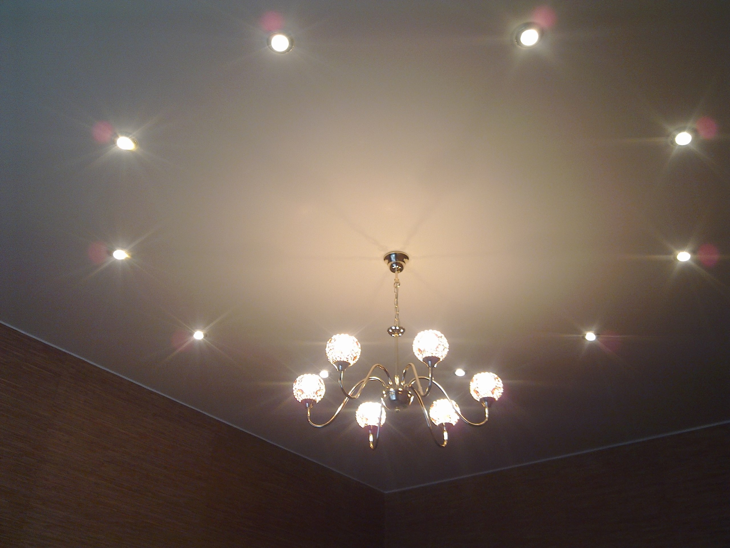 Spotlights and chandeliers on a suspended ceiling.