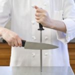 A cook sharpens a knife with musat.