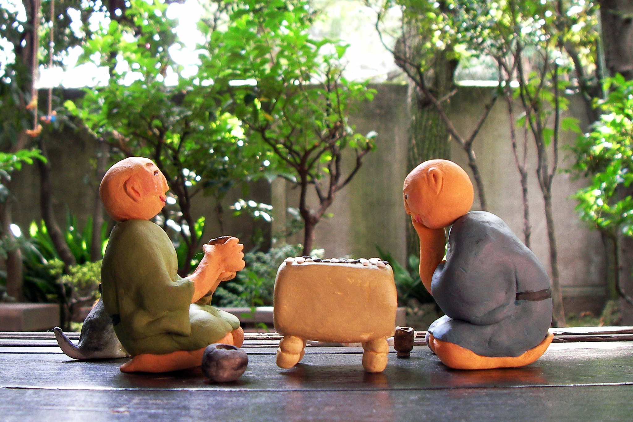 Two clay men playing a board game