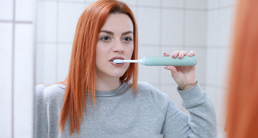 Brushing your teeth with an electric toothbrush