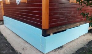Insulation of a pile foundation of a wooden house from the outside
